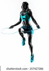 one caucasian woman exercising  Jumping Rope fitness in studio silhouette isolated on white background