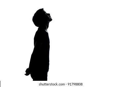 one caucasian young teenager silhouette boy or girl looking up portrait in studio cut out isolated on white background