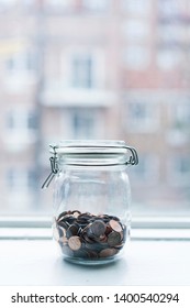 Lot Of One Cent Coins In A Glasses Jar By A Window