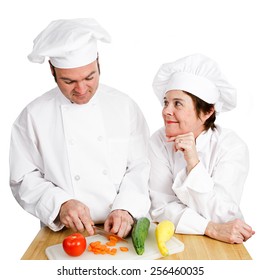 One Chef Observes Another's Prep Work, Chopping Vegetables.  Isolated On White.  