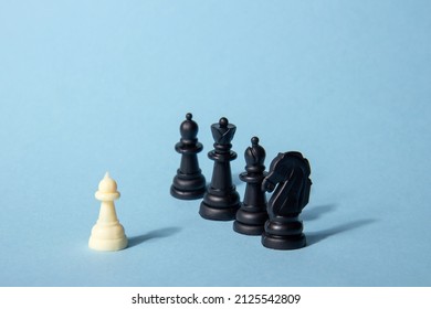 One Chess Piece Against Black Chess Pieces On A Blue Background With Contrasting Shadows. Abstract Background. Concept Of Leadership