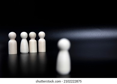 One child figure standing outside the group being excluded. Concept picture about someone being different or extraordinary. bullied and left out on black background copy space space for text - Shutterstock ID 2102222875