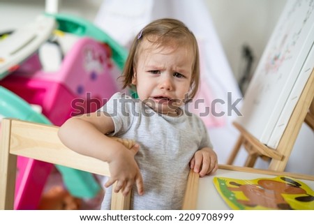 One child small caucasian girl toddler standing at home n room crying looking to the camera frustrated childhood unpleasant growing up concept copy space Foto stock © 