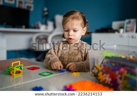 Similar – Baby girl playing with hair clips sitting in the floor