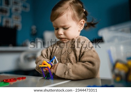 Similar – Baby girl playing with hair clips sitting in the floor