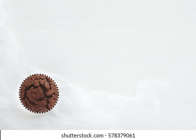 One Chocolate Muffin On White Wooden Table. Top View. 