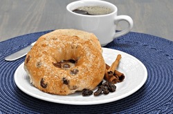One Cinnamon Raisin Bagel Buttered And Toasted With A Side Of Coffee.
