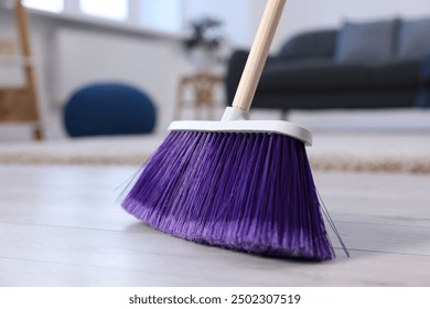 One cleaning broom on wooden floor indoors, closeup - Powered by Shutterstock