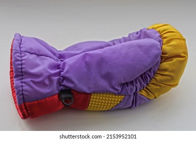 One Colored Winter Woolen Mitten With A Pattern Lies On A Gray Table