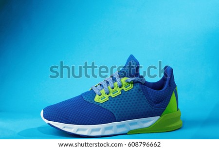 One colorful new modern shoe isolated on blue background. One sneaker shoe