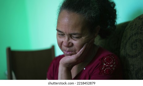 One Depressed Senior Woman Covering Face With Regret. An Older Hispanic South American Older Lady Feeling Anxiety