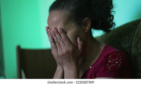 One Depressed Senior Woman Covering Face With Regret. An Older Hispanic South American Older Lady Feeling Anxiety