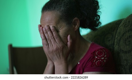 One Depressed Senior Woman Covering Face With Regret. An Older Hispanic South American Older Lady Feeling Anxiety