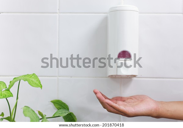 one dirty hand under the hand wash-Automatic\
soap dispenser