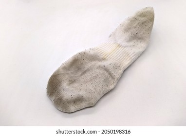one dirty sock on white background. closeup photo