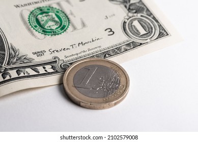 Un billet de un dollar et une pièce d'un euro sur fond blanc. Paiements internationaux et comparaison des taux de change.