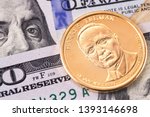 one dollar golden coin with Harry S. Truman portrait, and hundred dollars banknotes, macro
