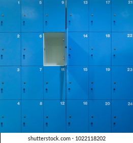 one door of blue locker open inside a school bathroom