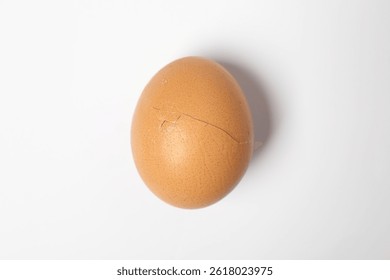 One egg with cracked shell on white background, top view