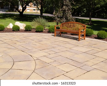 One Empty Wood Bench By A Stone Patio