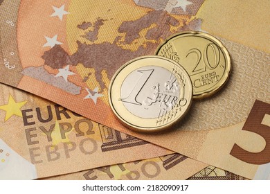 One euro and twenty cents coins on the red fifty paper bills.