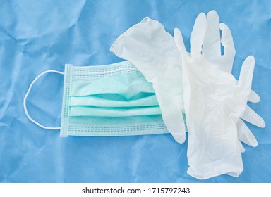 One face mask and white latex gloves on blue background.Medical tool for personal protection equipment.Medical accesory for infectious control concept. - Shutterstock ID 1715797243