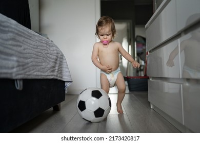 One Female Toddler Caucasian In Diapers Running In The House With Soccer Ball Early Child Development Learning And Playing Concept