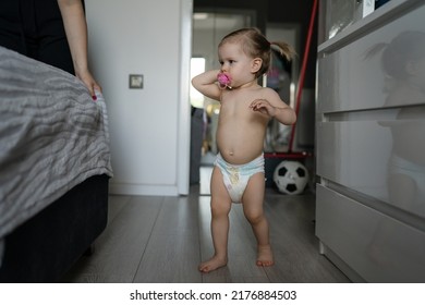 One Female Toddler Caucasian In Diapers Running In The House With Comb In Her Hand Early Child Development Learning And Playing Concept