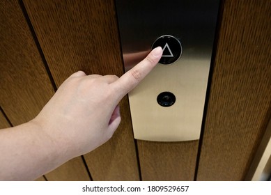 One finger touch the up symbol of elevator button.