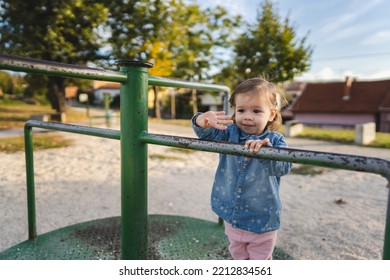 One Girl Small Caucasian Child Female Toddler 18 Months Old In Park Play In Day On Speedy Spinner Merry-go-round Turnabout Childhood And Growing Up Concept Copy Space