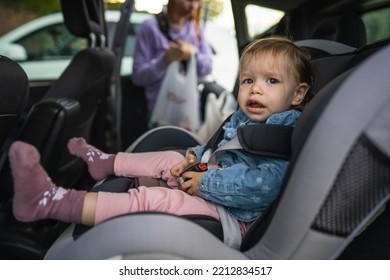 One Girl Small Caucasian Toddler Female Child Sitting In The Safety Car Seat Chair 18 Months Old Transportation Concept Copy Space