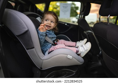 One Girl Small Caucasian Toddler Female Child Sitting In The Safety Car Seat Chair 18 Months Old Transportation Concept Copy Space