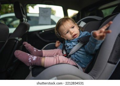 One Girl Small Caucasian Toddler Female Child Sitting In The Safety Car Seat Chair 18 Months Old Transportation Concept Copy Space