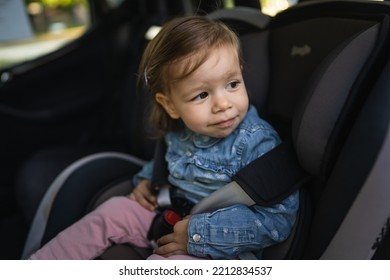 One Girl Small Caucasian Toddler Female Child Sitting In The Safety Car Seat Chair 18 Months Old Transportation Concept Copy Space