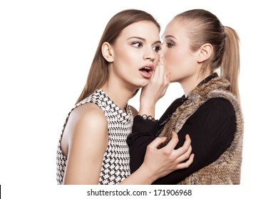 one girl whispers bad news to another girl