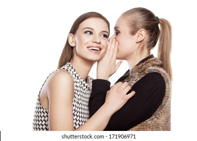 one girl whispers good news to another girl