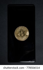 One Golden Bitcoin On Celphone Or Smartphone Screen As Financial Investment In Virtual Money Concept