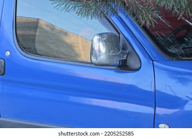 One Gray Metal Review Mirror Hanging On A Blue Car In The Street