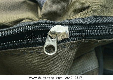 one gray metal zip on black green fabric bag