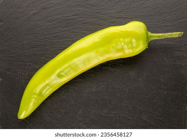 One green chili pepper on slate stone, macro, top view. - Powered by Shutterstock