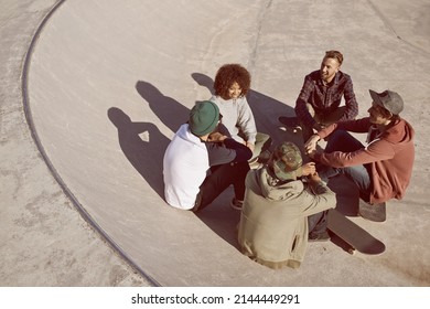 One Of The Guys. Shot Of A Group Of Friends Hanging Out In The Sun At A Skate Park.