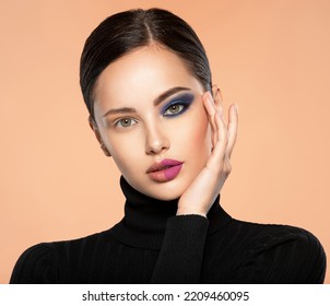 One half face of a beautiful white woman with  bright makeup and the other is natural. Woman portrait with a deep blue eye makeup of one eye. Natural and  vivid make-up on a female face. Fashion style