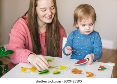 One and a half year old girl and her mother collects puzzles. Psychomotor skills and the development of logical thinking