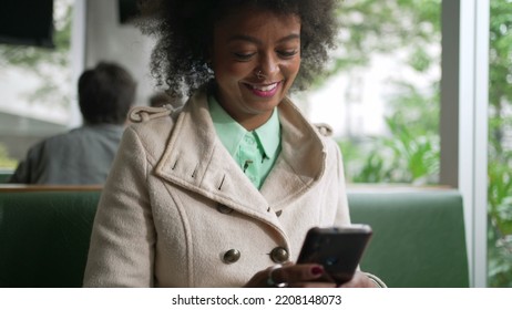 One Happy Black Woman Checking Phone At Coffee Shop. Smiling African American Girl With Afro Hair Reading Cellphone Message
