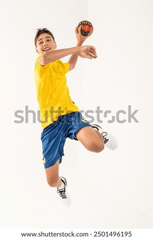 One happy handball player, teenager boy in studio isolated on white background. Hobby and healthy lifestyle concept. Copy space. Full lenght photo.
