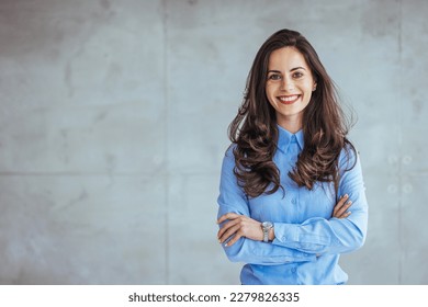 One Happy Pretty Business Woman Standing in Hall and looking at camera with smile. Studio headshot on white background. Spanish model. Portrait of a confident young businesswoman