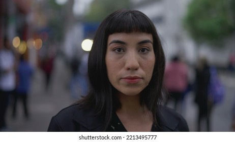 One Hispanic Young Woman Standing In Street. South American Latina Brazilian Female Person Closeup Face With Serious Expression Looking At Camera