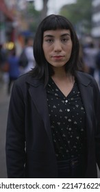 One Hispanic Young Woman Standing In Street. South American Latina Brazilian Female Person Closeup Face With Serious Expression Looking At Camera In Vertical Vide