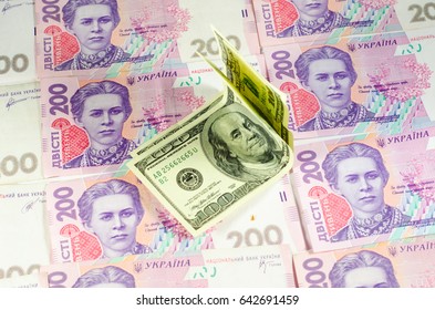 One hundred dollars banknotes on the heap of ukrainian hryvnas