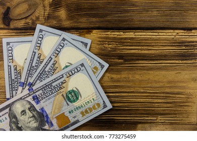 One hundred dollars bills on wooden desk